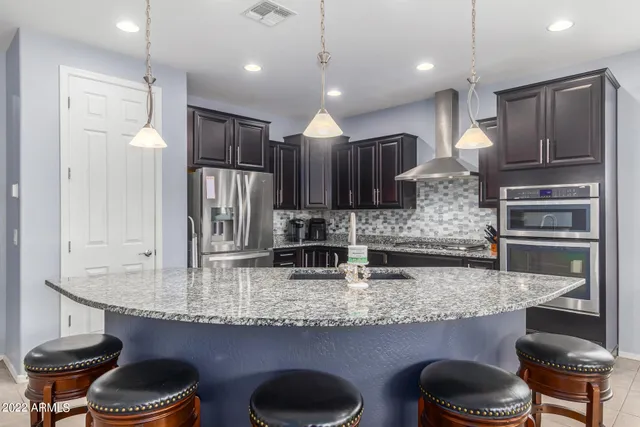 a kitchen with stainless steel appliances granite countertop a stove refrigerator and cabinets