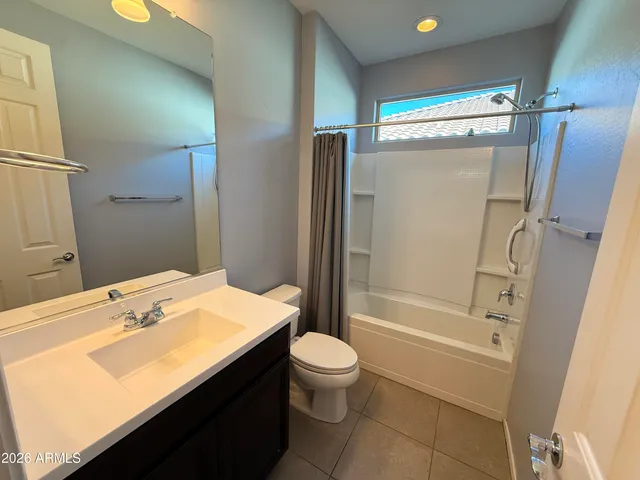 a bathroom with a sink a toilet a mirror and shower