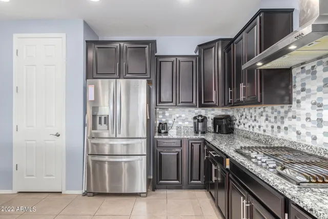 a kitchen with stainless steel appliances granite countertop a refrigerator and a stove top oven