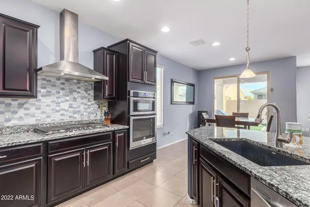 a kitchen with granite countertop stainless steel appliances and wooden cabinets