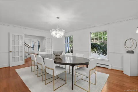 a dining room with furniture a chandelier and wooden floor