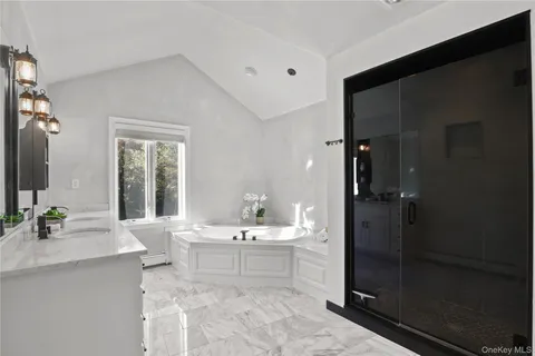 a bathroom with a double vanity sink mirror and shower