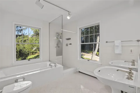 a bathroom with a tub sink and mirror