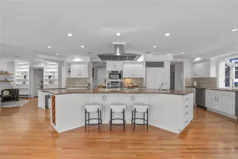 a large white kitchen with lots of counter space and stainless steel appliances