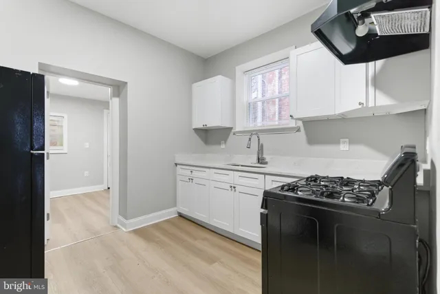 a kitchen with stainless steel appliances granite countertop a stove a sink dishwasher and a refrigerator with wooden floor