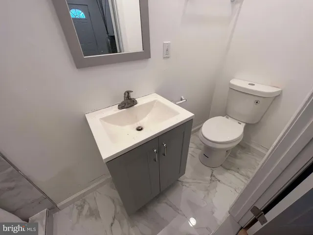 a bathroom with a sink toilet and mirror