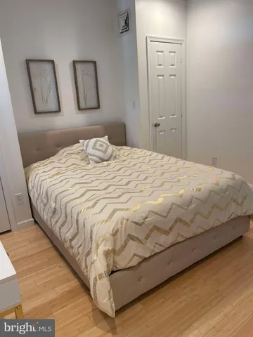 a bedroom with a bed and painting on the wall