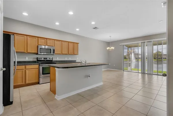a kitchen with stainless steel appliances granite countertop a stove a sink a microwave and a refrigerator