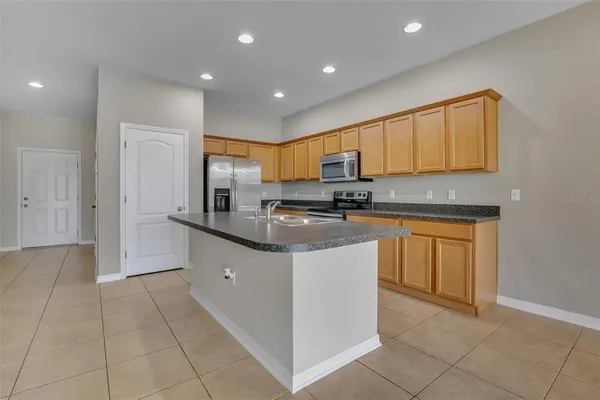 a kitchen with stainless steel appliances granite countertop a stove a sink and a refrigerator