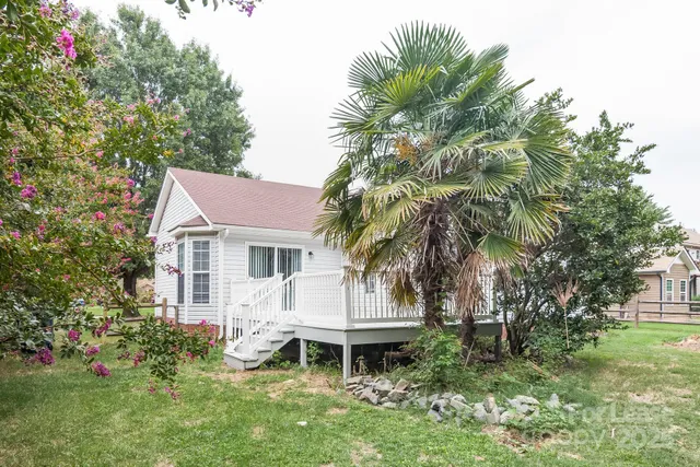 a front view of a house with a garden and trees