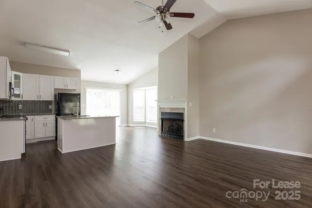 a view of open kitchen with granite countertop a stove top oven sink and cabinets