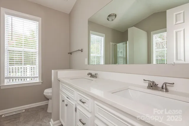 a bathroom with a sink a toilet and a window