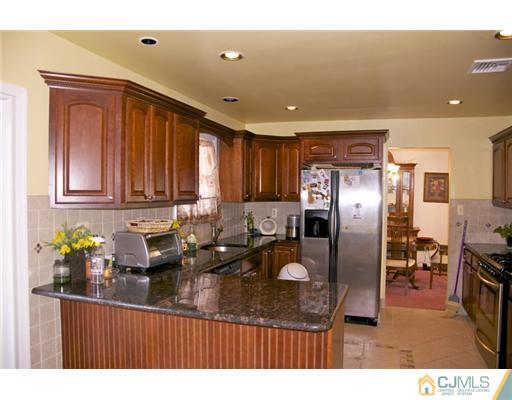 521 New Brunswick Road Somerset, NJ 08873 - Photo 3 of 11 a kitchen with stainless steel appliances granite countertop a sink refrigerator and cabinets