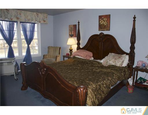 521 New Brunswick Road Somerset, NJ 08873 - Photo 7 of 11 a bedroom with a bed and wooden floor