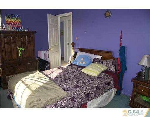 521 New Brunswick Road Somerset, NJ 08873 - Photo 9 of 11 a bedroom with a bed and a lamp on dresser