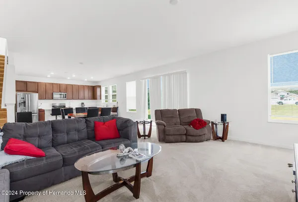 a living room with furniture and kitchen view