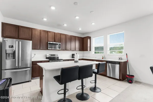 a kitchen with stainless steel appliances granite countertop a stove a sink a refrigerator and a refrigerator