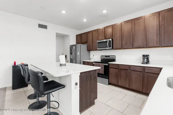 a kitchen with stainless steel appliances a stove a sink a microwave a refrigerator and cabinets