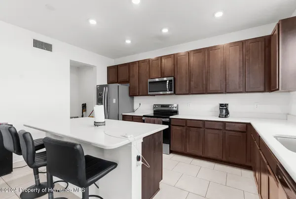 a kitchen with a sink a microwave a refrigerator and cabinets