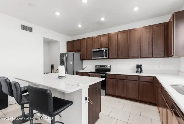 a kitchen with a sink a microwave a refrigerator and cabinets