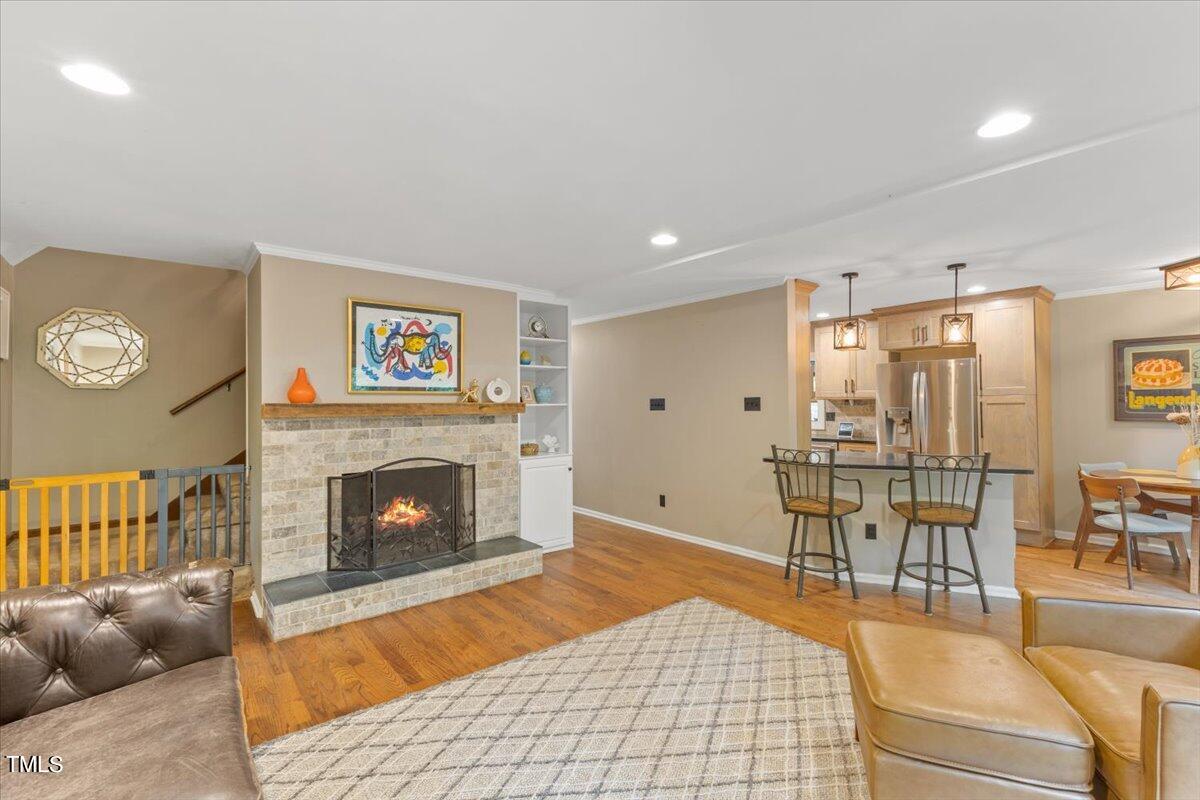 6713 Laurdane Road Raleigh, NC 27613 - Photo 12 of 47 a living room with furniture a fireplace and a table