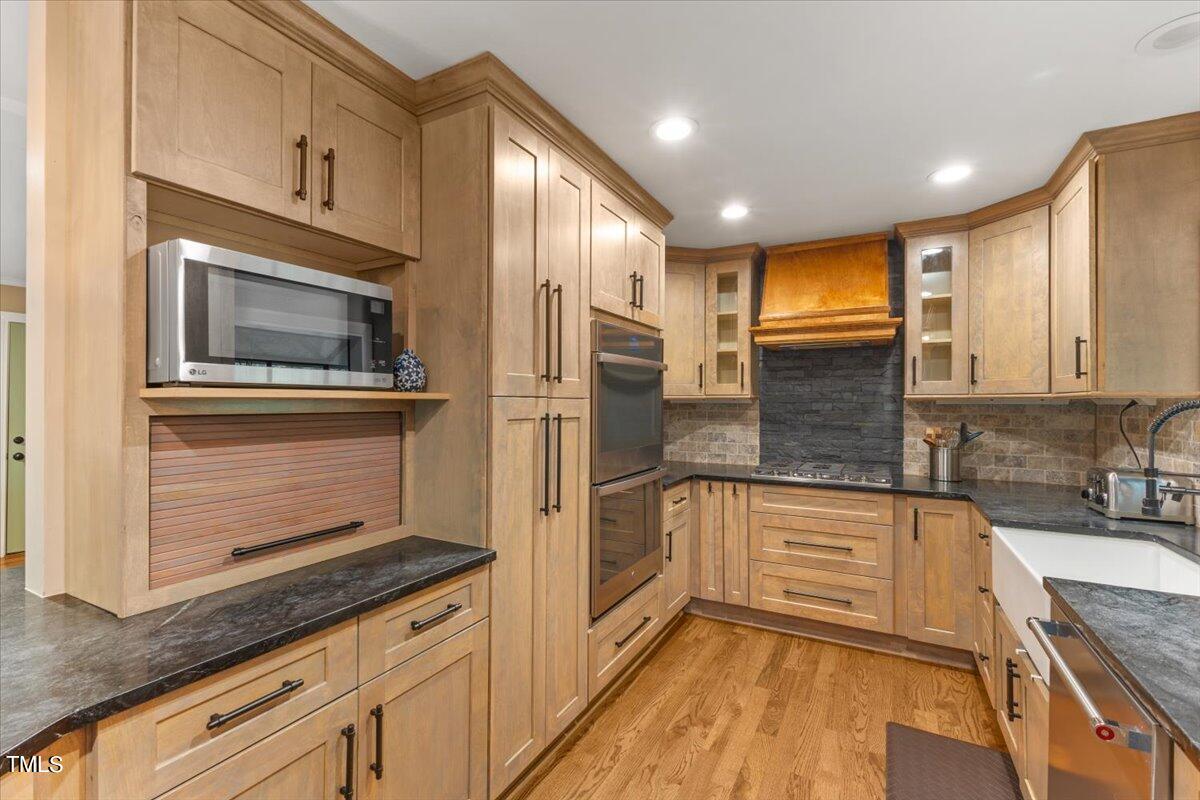 6713 Laurdane Road Raleigh, NC 27613 - Photo 14 of 47 a kitchen with stainless steel appliances granite countertop a refrigerator and a stove top oven