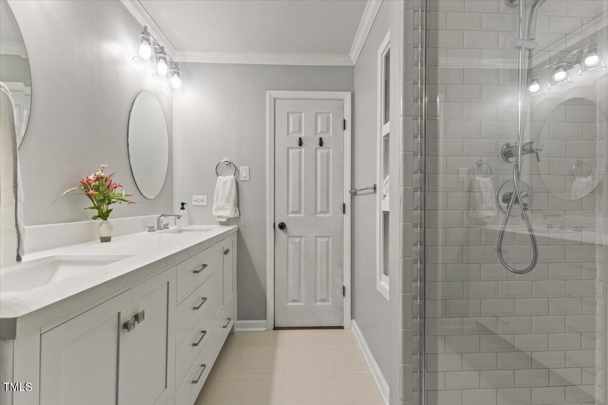 6713 Laurdane Road Raleigh, NC 27613 - Photo 17 of 47 a bathroom with a double vanity sink mirror and shower