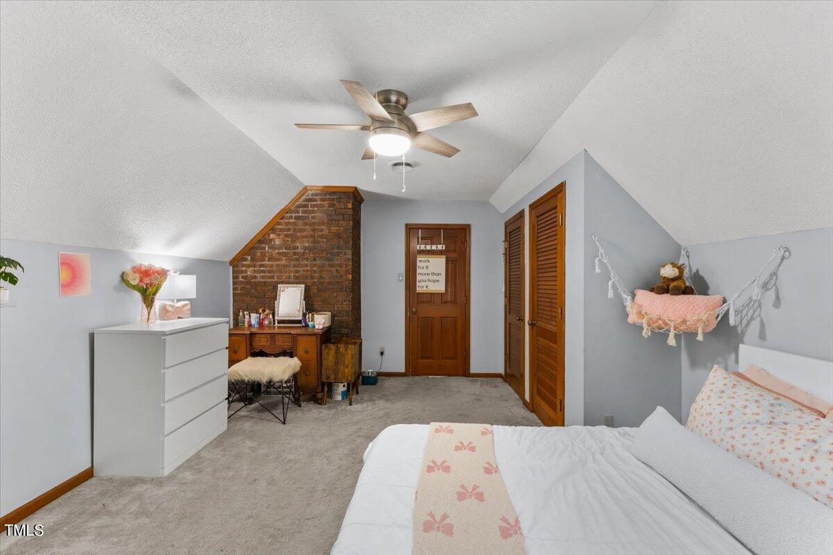 6713 Laurdane Road Raleigh, NC 27613 - Photo 20 of 47 a bedroom with a bed and a chandelier