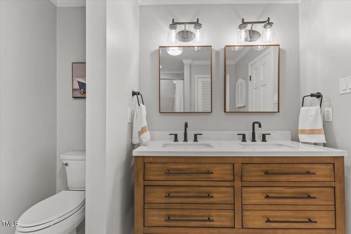 6713 Laurdane Road Raleigh, NC 27613 - Photo 21 of 47 a bathroom with a granite countertop sink vanity mirror and toilet