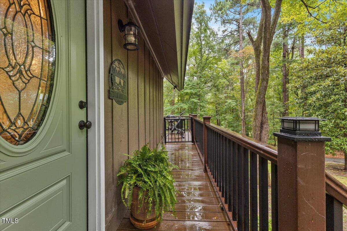 6713 Laurdane Road Raleigh, NC 27613 - Photo 7 of 47 a balcony with wooden floor stairs and trees