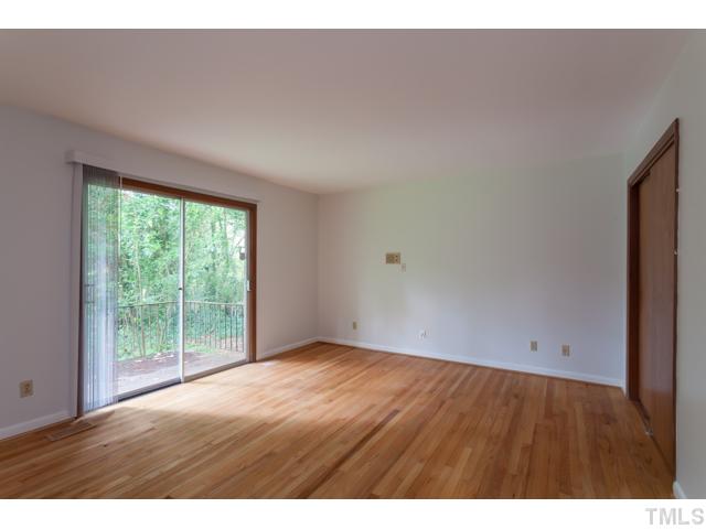 11709 Strickland Road Raleigh, NC 27613 - Photo 11 of 25 a view of an empty room with wooden floor and a window