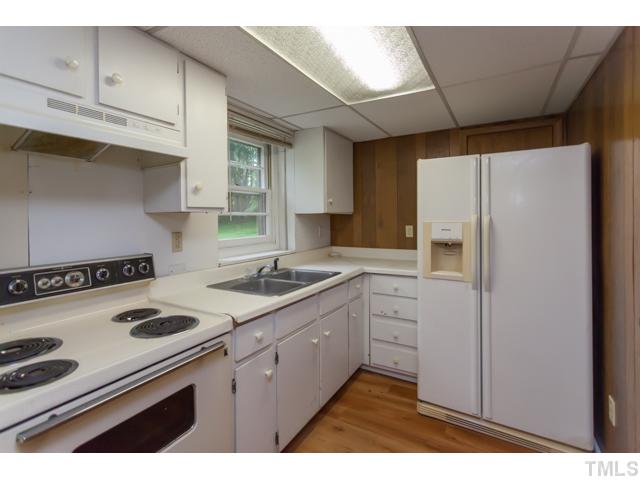 11709 Strickland Road Raleigh, NC 27613 - Photo 19 of 25 a kitchen with a stove cabinets and a refrigerator