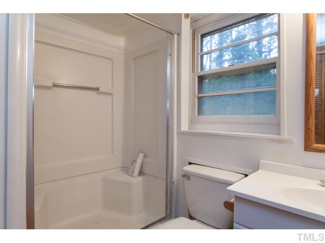 11709 Strickland Road Raleigh, NC 27613 - Photo 20 of 25 a bathroom with a sink a toilet and a window