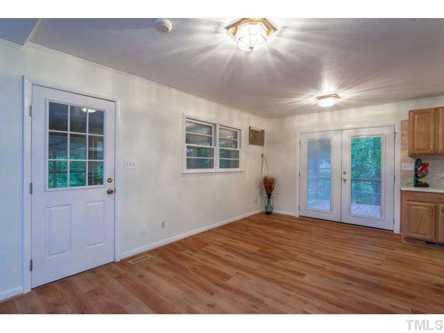 11709 Strickland Road Raleigh, NC 27613 - Photo 6 of 25 a view of an empty room with a window and wooden floor