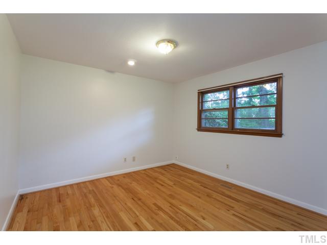 11709 Strickland Road Raleigh, NC 27613 - Photo 8 of 25 a view of an empty room with wooden floor and a window