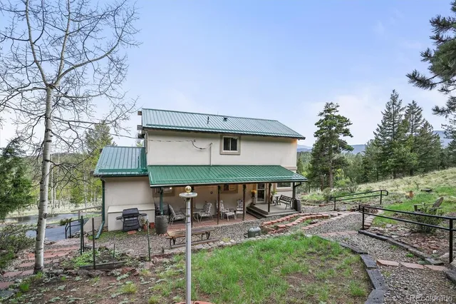 a view of a house with backyard and sitting area