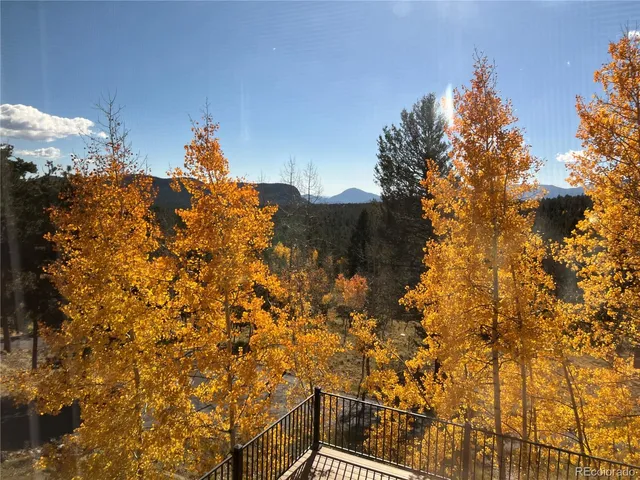 a living room with furniture large window and wooden floor