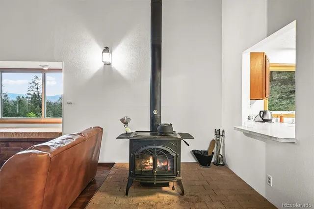 a living room with fireplace furniture and a large window