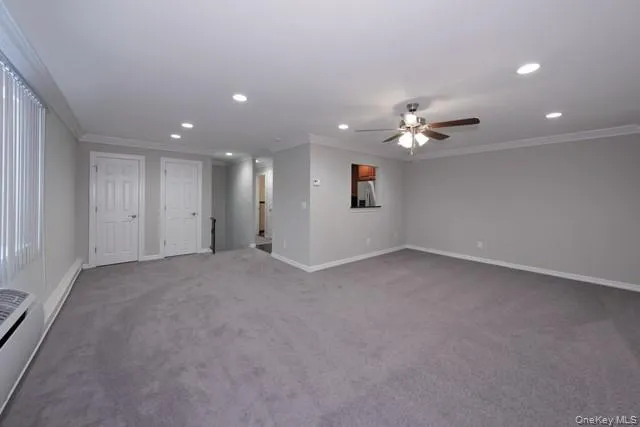 a view of an empty room with a ceiling fan