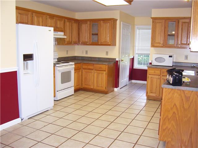 1075 Cliff White Road Columbia, TN 38401 - Photo 3 of 20 Spacious kitchen, oak cabinets, tile flooring. Half bath and laundry room at the back of kitchen by window.