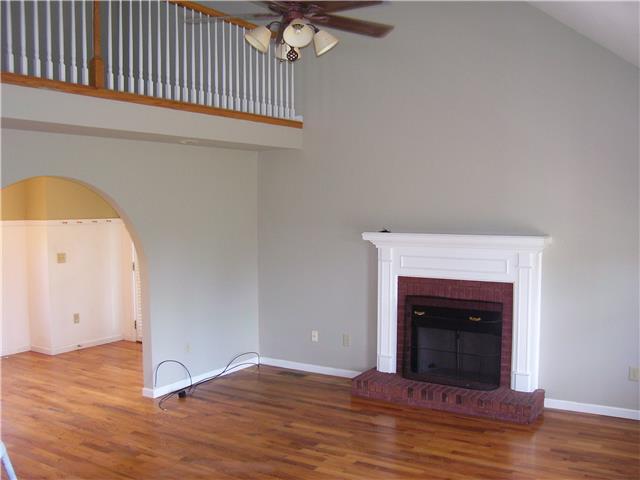 1075 Cliff White Road Columbia, TN 38401 - Photo 5 of 20 Large, open living room with gas fireplace, cathedral ceiling, hardwood floor, ceiling light and fan, plus canned lighting.