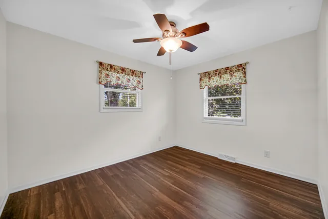 a view of empty room with wooden floor