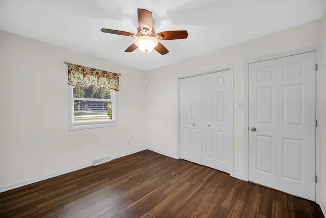 a view of empty room with wooden floor