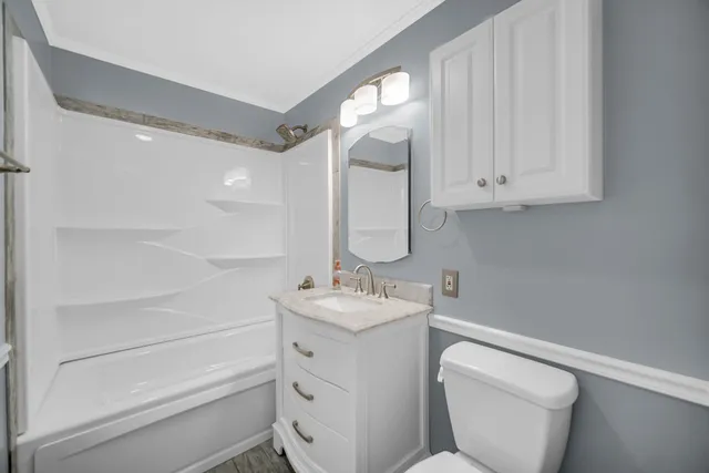 a bathroom with a toilet sink and mirror