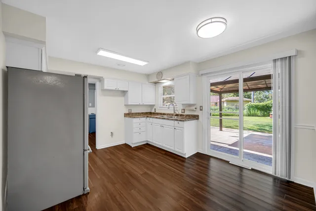 a kitchen with a refrigerator and white cabinets