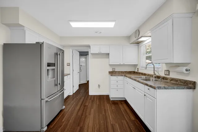 a kitchen with a refrigerator a sink and dishwasher a oven with wooden floors