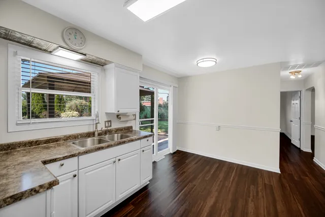 a kitchen with a sink and wooden floor