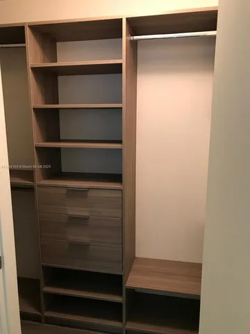 a view of walk in closet with empty racks