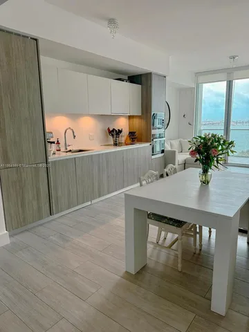 a view of a kitchen area with furniture and wooden floor