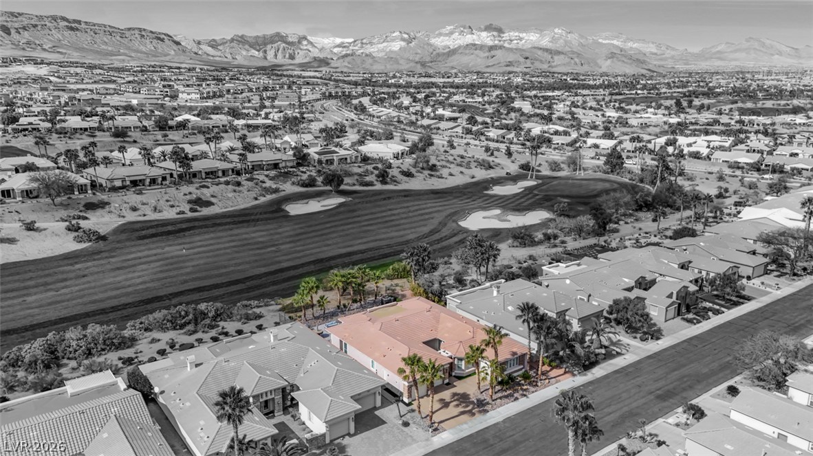 5015 Rivedro Street Las Vegas, NV 89135 - Photo 68 of 91 An aerial perspective reveals a desert oasis community with homes bordering a pristine golf course, set against a majestic mountain backdrop.